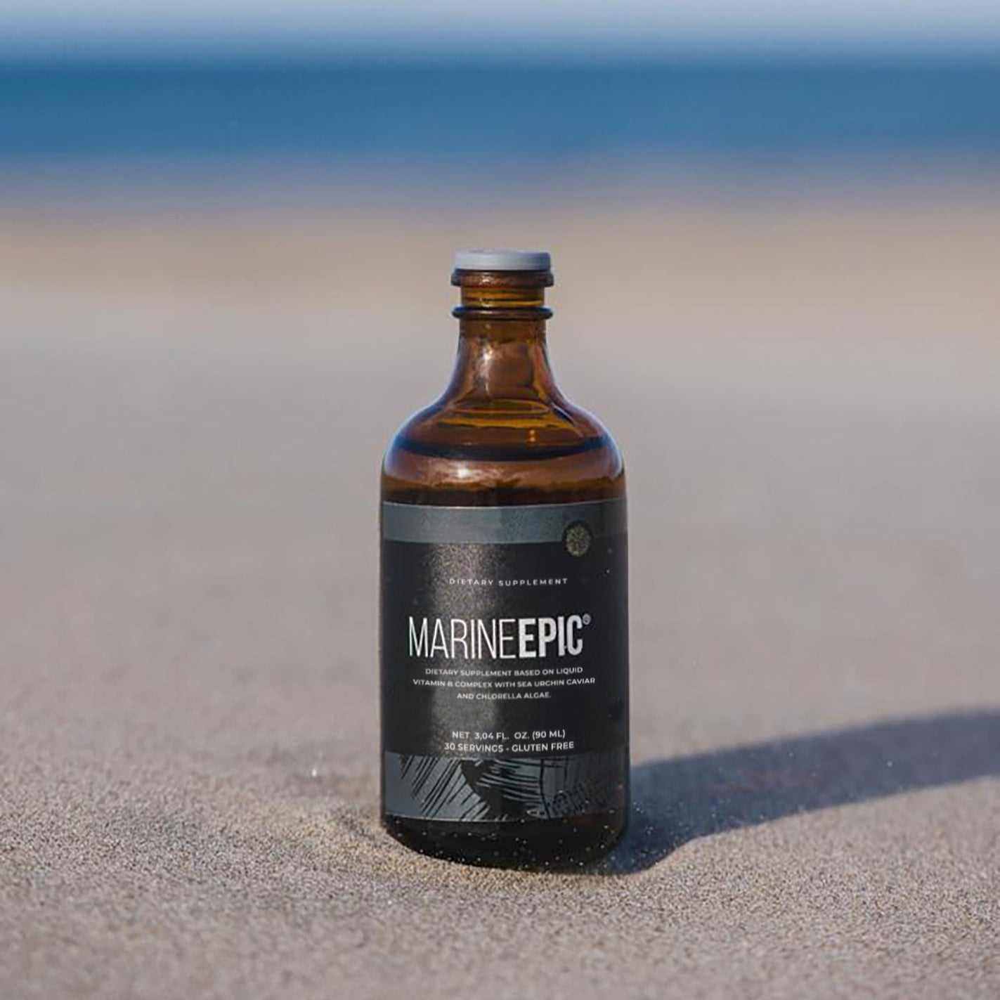 Marine Epic biotechnology supplement bottle on sandy beach for longevity and anti-aging biohacking